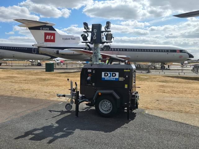 Tower light on an airfield apron beside heritage aircraft